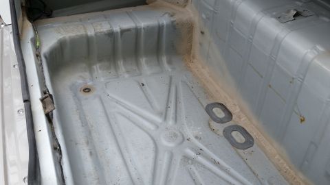 1991 Ford LTD Crown Victoria - The bare metal floor of a car's interior, stripped of carpeting and trim.