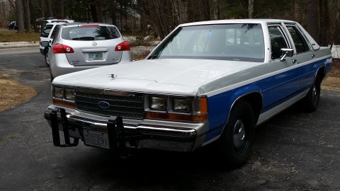 1991 Ford LTD Crown Victoria - A two-tone Ford Crown Victoria, likely from the early 1990s, is seen from a three-quarter front view.