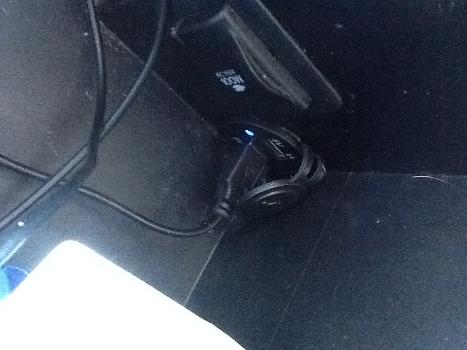 Car's center console with a USB adapter plugged into the 12V outlet. There's also a 100W AC inverter visible
