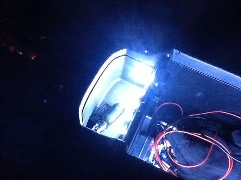 2005 Toyota 4Runner - Exposed wiring and a bright blue light are visible within a dark vehicle interior compartment.