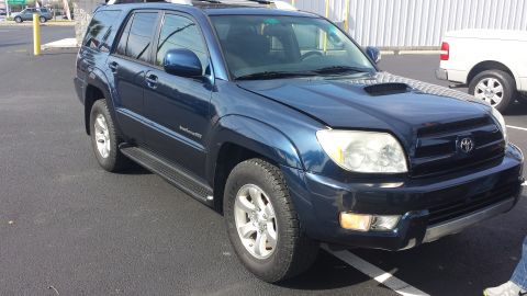 2005 Toyota 4Runner - A blue Toyota 4Runner is parked outside with a white truck in the background.