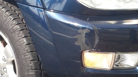 2005 Toyota 4Runner - Front fender of a blue SUV shows damage and wear. The vehicle is identified as a 2005 Toyota 4Runner.