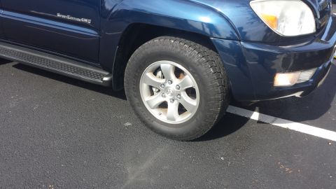 2005 Toyota 4Runner - Front passenger side of a blue 2005 Toyota 4Runner, showing the wheel and fender area.