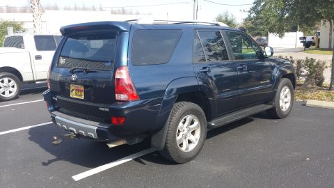 2005 Toyota 4Runner - This dark blue 2005 Toyota 4Runner is parked in a lot, with a white pickup truck to its left.