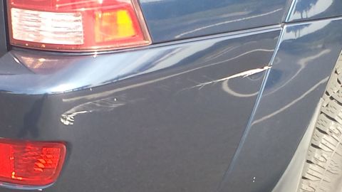 2005 Toyota 4Runner - Scratches mar the rear quarter panel of a dark blue SUV, obscuring its exact model year.