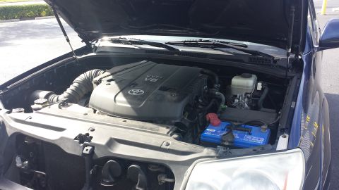 2005 Toyota 4Runner - The engine compartment of a 2005 Toyota 4Runner is open, revealing the V6 engine and a blue battery.