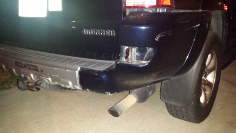2005 Toyota 4Runner - Rear view of a damaged dark blue SUV, identified as a 4Runner, with a broken taillight and exhaust pipe.