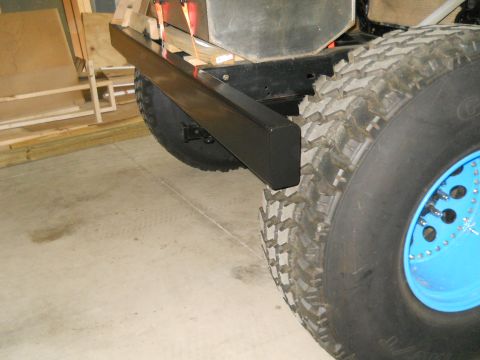 1992 Ford Bronco - Close-up view of the rear bumper and a large off-road tire with a bright blue wheel.