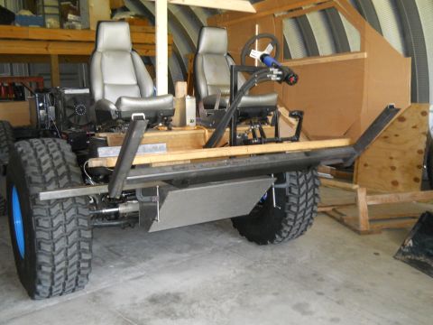 1992 Ford Bronco - This custom-built vehicle chassis is in a workshop, two seats and large off-road tires.