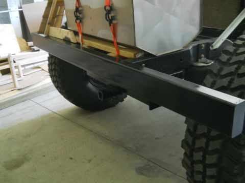1992 Ford Bronco - Close-up of a vehicle's rear bumper and tire, with a cargo box secured above.
