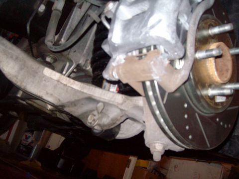 2004 Ford Crown Victoria - Front brake caliper and rotor assembly shown from below.