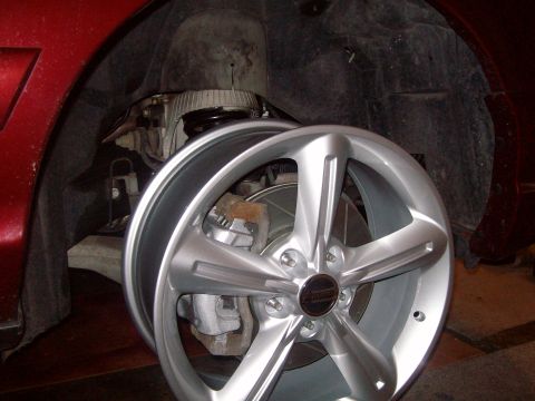 2004 Ford Crown Victoria - A close-up view of a silver aftermarket wheel and brake caliper assembly, likely part of a vehicle repair or upgrade.