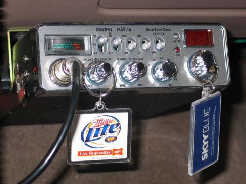 1995 Ford Bronco - CB radio with two promotional keychains hanging from it.