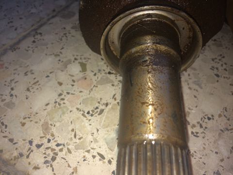 2011 Ford Elite - A close-up view of a CV shaft and seal, showing signs of wear and tear.