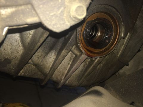 2011 Ford Elite - This image shows a close-up view of a vehicle's drivetrain seal, likely needing replacement due to wear and fluid leakage.
