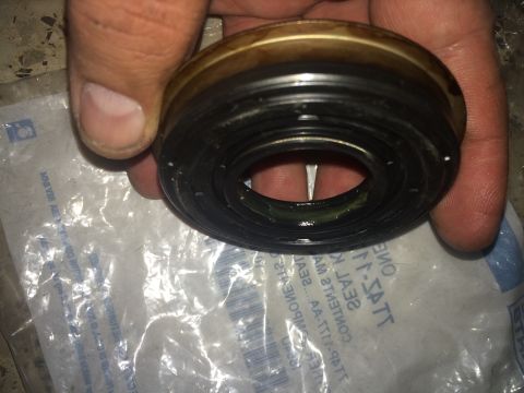 2011 Ford Elite - A CV shaft seal is held in hand over its packaging, which shows some reversed text.