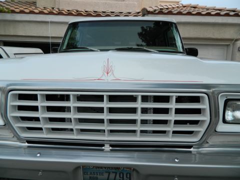 1979 Ford Bronco - This 1979 Ford Bronco features a distinctive white grille and custom red pinstriping on its hood.