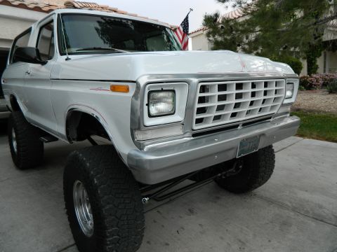 1979 Ford Bronco - This lifted white 1979 Ford Bronco features a prominent chrome grille and a distinctive body style.