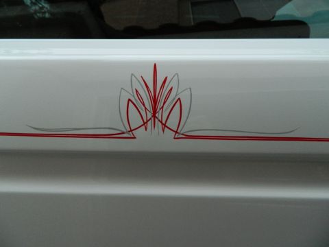 1979 Ford Bronco - Detailed pinstriping adorns the side of a vehicle, custom artistry.