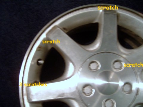 1997 Ford Taurus - This alloy wheel has several scratches marked with yellow text.