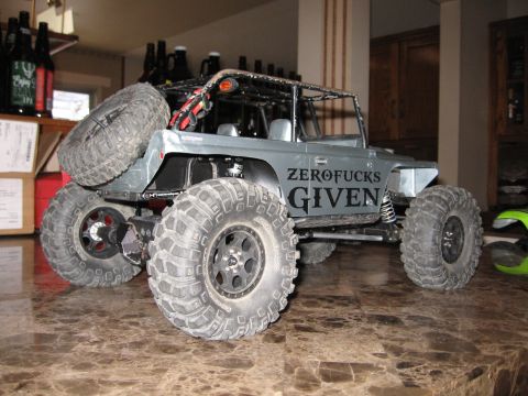 1993 Toyota 4Runner - This custom off-road vehicle features large tires, a roll cage, and prominent text on its side.