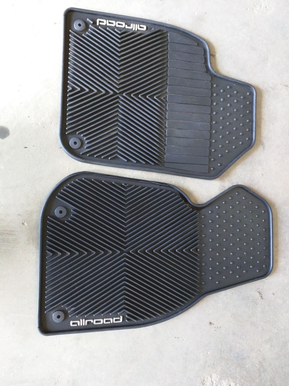 Two black rubber allroad floor mats with textured patterns and circular fasteners