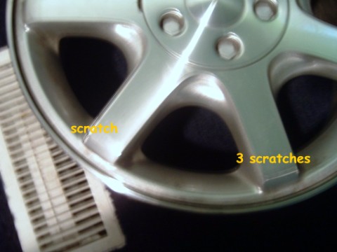 1997 Ford Taurus - This image shows an alloy wheel with visible scratches, along with text highlighting the damage.