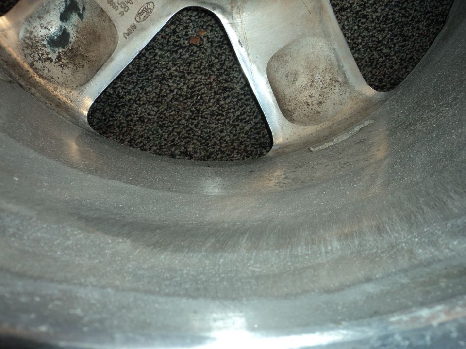 Close-up of a metal wheel rim with visible casting marks and some dirt