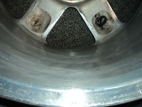 2004 Mercury Grand Marquis - This is a close-up view of a vehicle's wheel rim, revealing its metallic surface and some signs of wear.