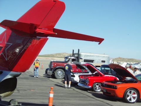 1995 Peterbilt 379 - A classic red truck is displayed alongside other vehicles and a portion of a red airplane.