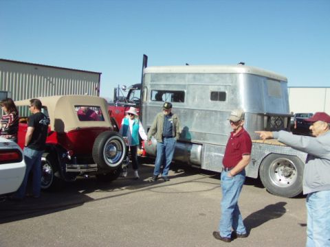 1995 Peterbilt 379 - Several people stand around a silver trailer truck and a red convertible at an outdoor event.