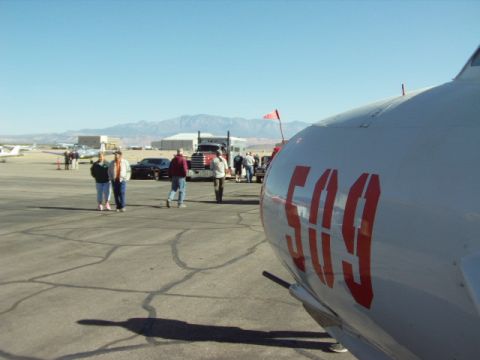 1995 Peterbilt 379 - A Peterbilt truck and other vehicles are visible on an airfield, with the foreground dominated by the side of a white aircraft marked with…