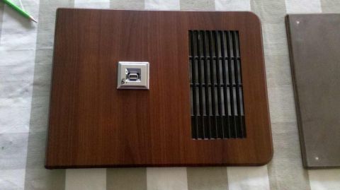 1982 Ford Bronco - This wood-grain door trim panel features a chrome pull and a black vent, likely an interior component from a vehicle.