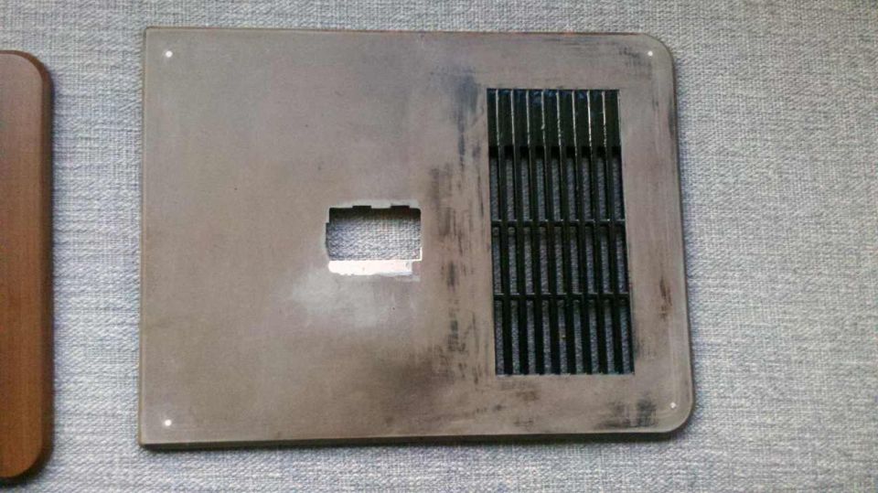 Brown door trim panel with rectangular cutout and a vent grille