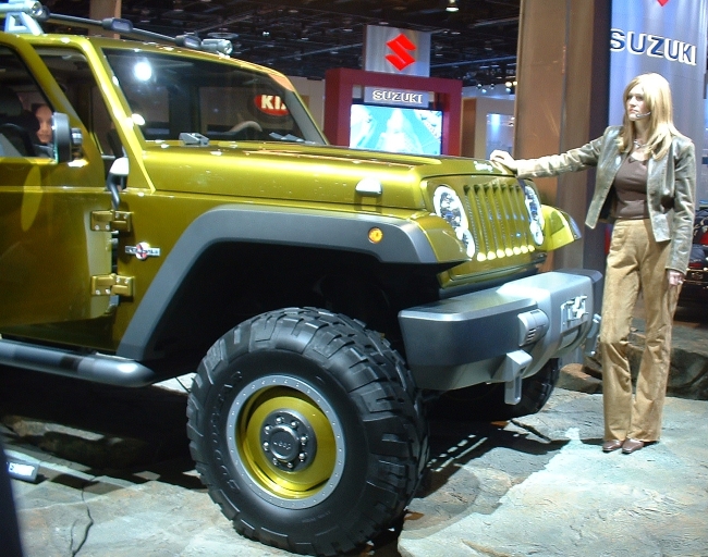 Yellow-green Jeep Wrangler concept on a show stand with a presenter