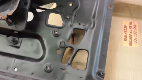 1978 Ford Bronco - This is a close-up view of the internal structure of a vehicle's door panel, with a shipping inspection sticker visible.