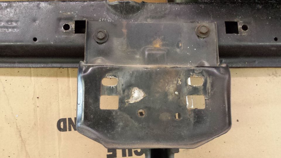 Close-up of a black metal vehicle frame bracket with mounting holes