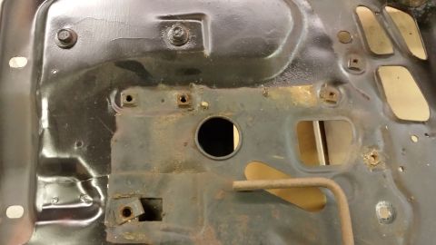 1978 Ford Bronco - Close-up of a vehicle chassis part, showing mounting holes and signs of wear.