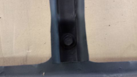 1978 Ford Bronco - Close-up view of a black plastic trim piece secured by a bolt.