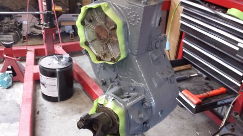 1978 Ford Bronco - Transmission being prepped for paint on an engine stand, with tools and a drum of fluid nearby.