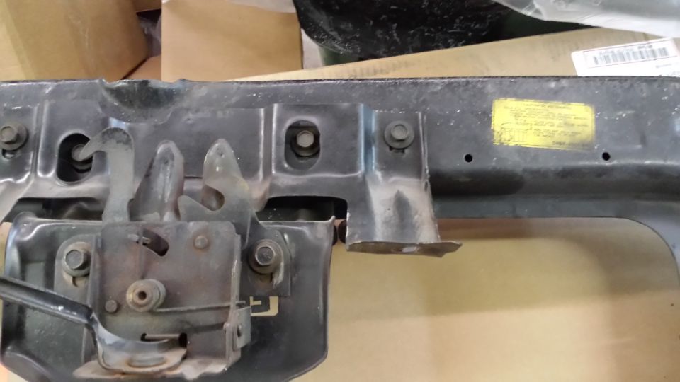 Hood latch mechanism with yellow sticker and Supermotors logo