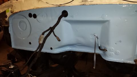 1978 Ford Bronco - The firewall of an engine bay is visible, coated in light blue primer and a wiring harness.