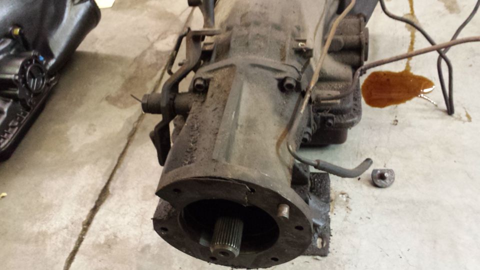 close-up of a transmission assembly with some fluid spilled on the concrete floor