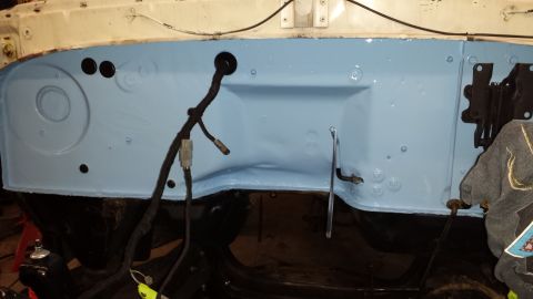 1978 Ford Bronco - The firewall of a vehicle, recently painted, shows a wiring harness and various mounting points.