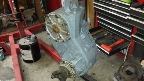 1978 Ford Bronco - A painted transfer case sits on an engine stand in a garage, ready for installation.