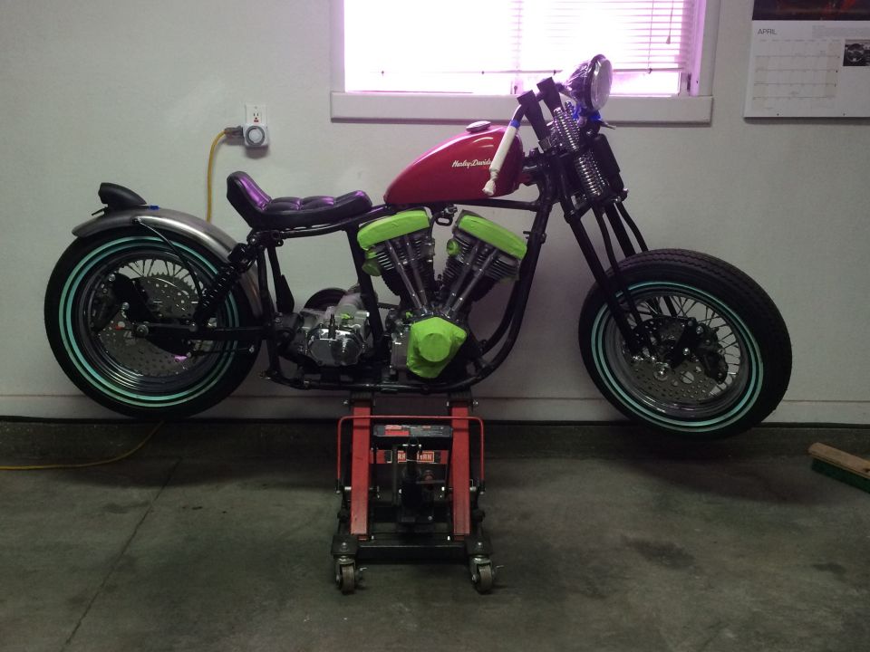Harley-Davidson motorcycle with red tank and green engine covers on a red lift
