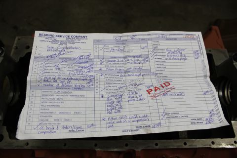 1979 Ford Bronco - A 'PAID' service document from Bearing Service Company is laid on top of an engine block.