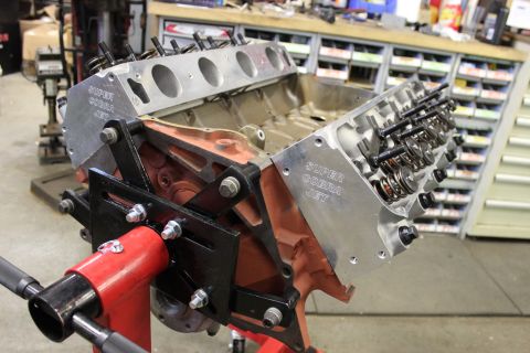 1979 Ford Bronco - Engine block with "Super Cobra Jet" lettering is mounted on a red stand in a workshop.
