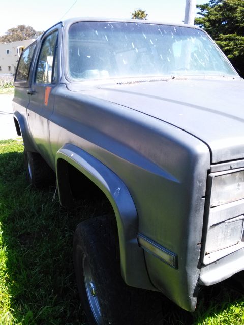 1991 Ford Bronco - This SUV's front end is visible from a three-quarter angle, parked outdoors on a sunny day.