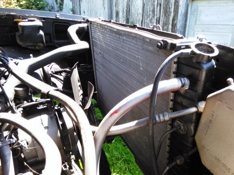 1991 Ford Bronco - Close-up view of the radiator and associated hoses within an engine bay.